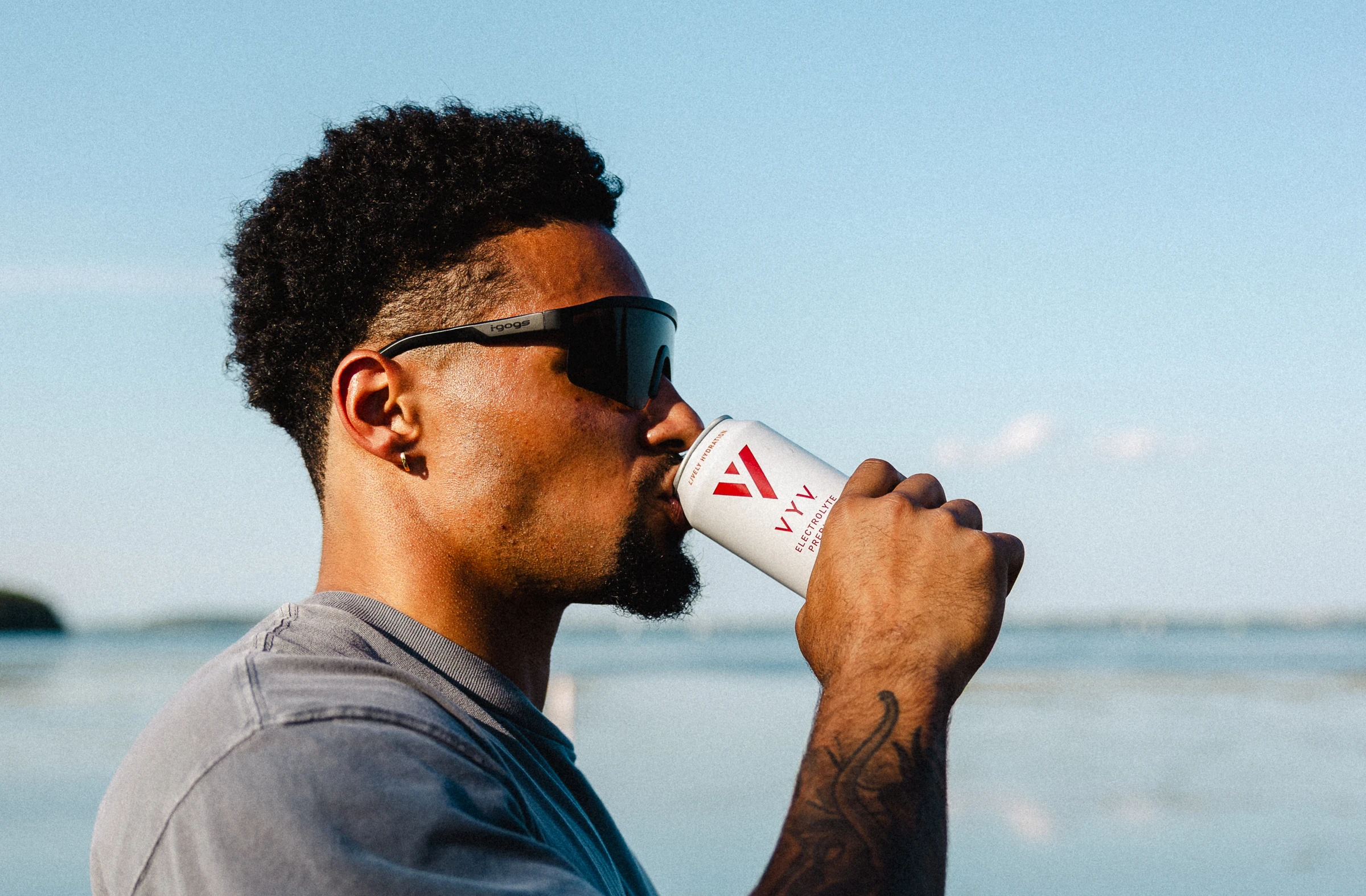 Austin Brown drinking VYV beside the lake, photographed by Courtney Terry